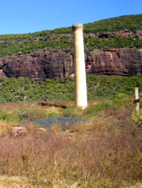 A chimney stands starkly agains the cliffs of outback Mt Mulligan (Ngarrabullgan)